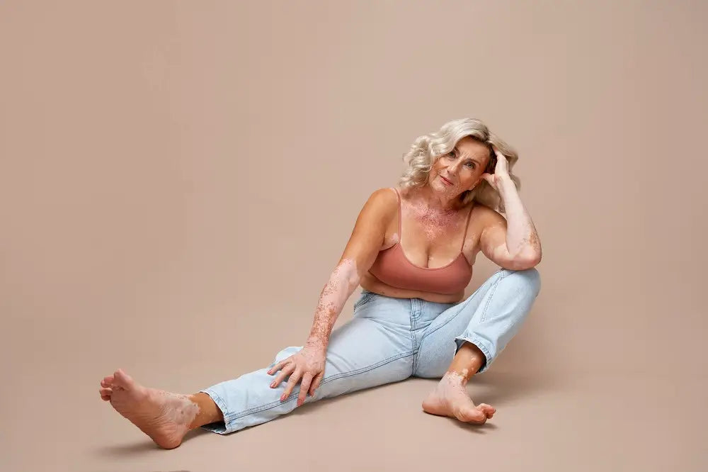 Une femme, jambes croisées, est assise sur le sol, exprimant une attitude de détente et de contemplation.