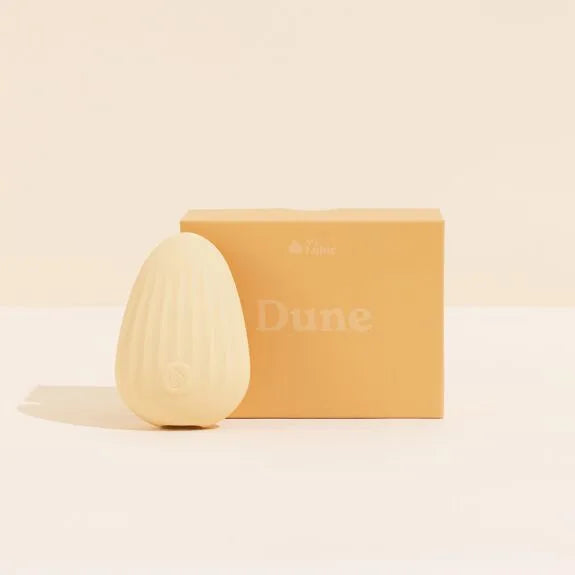 Vibromasseur intime élégant en silicone ondulé beige avec packaging moderne.