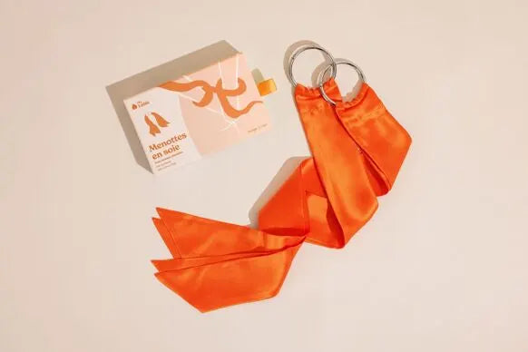 Menottes en soie orange élégantes pour jeux intimes, accessoire BDSM doux et luxueux pour des moments sensuels et raffinés.