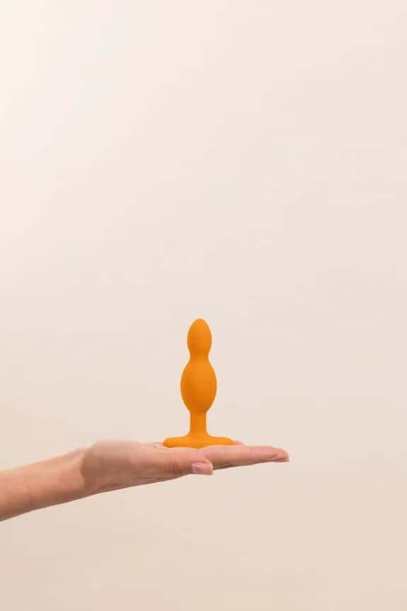 Bouton anal orange en silicone doux, idéal pour débutants et plaisir intense.