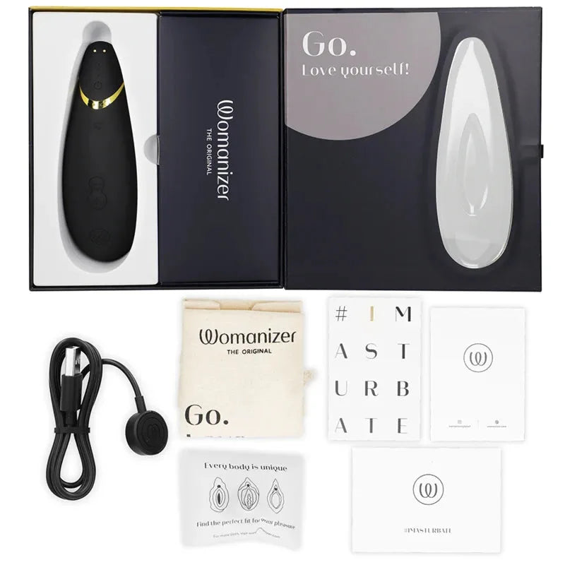 Stimulateur clitoridien noir Womanizer avec accessoires, design élégant, recharge USB incluse.
