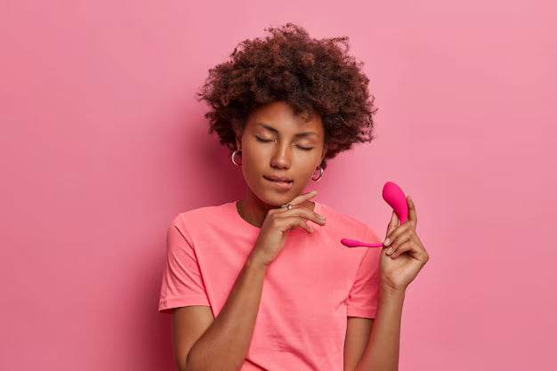 femme-peau-foncee-heureuse-tient-jouet-sexuel-vibrateur-application-pour-controler-vibrations-mord-levres-ferme-yeux-satisfaction-tient-oeuf-vibrateur-intelligent-silicone-isole-mur-rose-plaisir-erotique_273609-39676_dvgr71