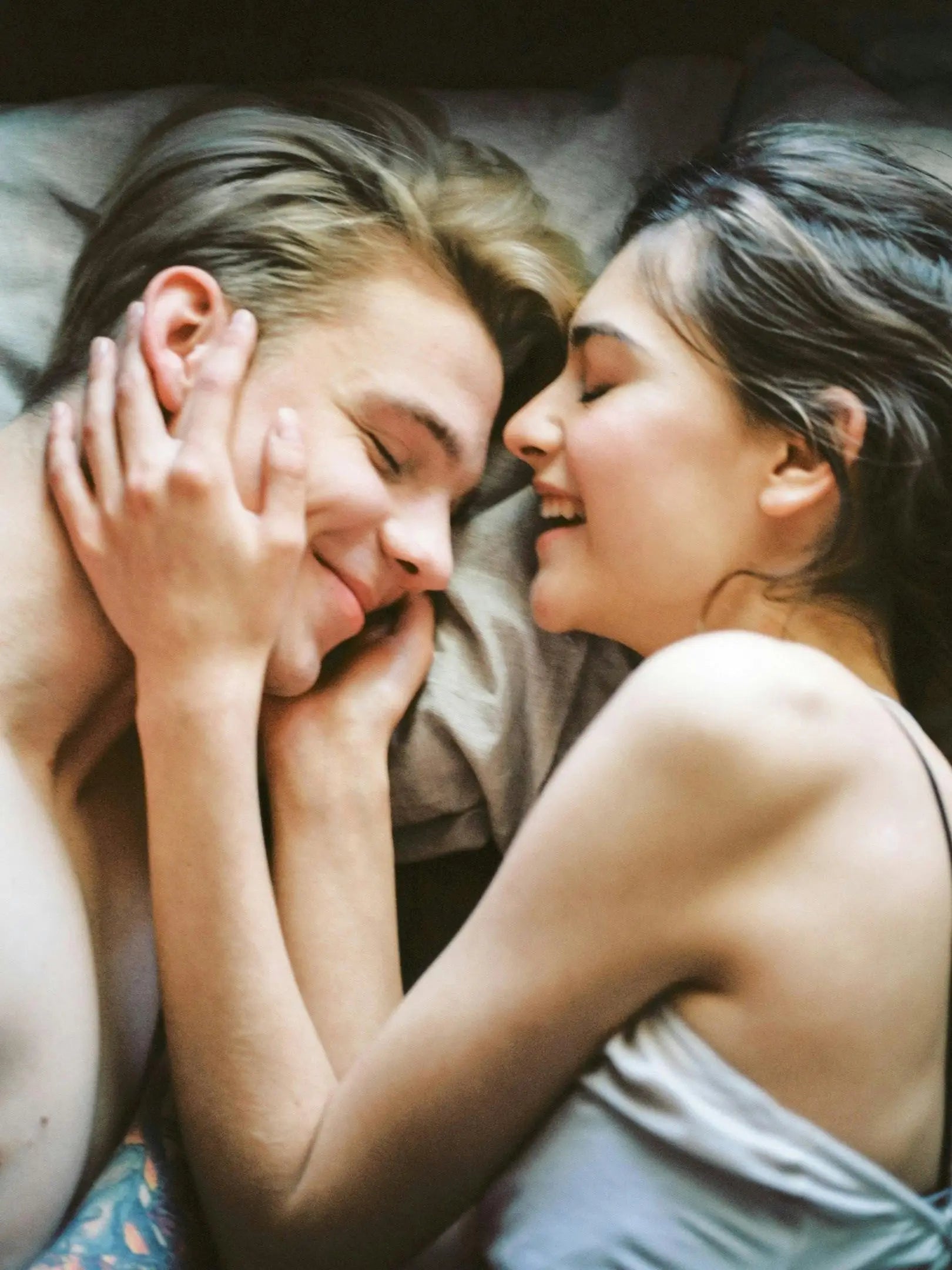 Couple au lit main sur visage de l'homme