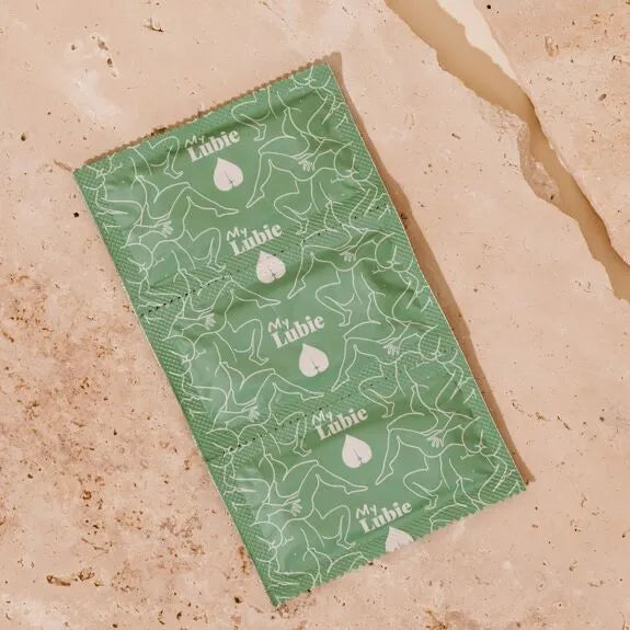 Préservatif écologique My Lubie sur fond texturé naturel, élégant et responsable pour un plaisir protégé.