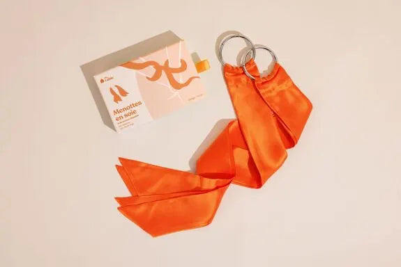 Menottes en soie orange élégantes, idéales pour des jeux érotiques raffinés et sensuels.